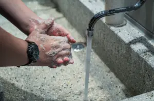 Hygiene im Katastrophenfall, Person wäscht sich am Waschbecken die Hände